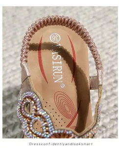 Detailansicht der Paillettenverzierung und Markenlogo auf flachen Boho-Sandalen