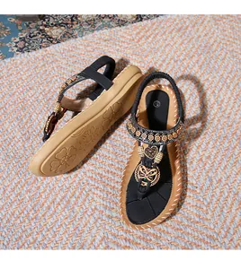 Detail of bohemian flat sandals with vintage metal heart charms and colorful beads
