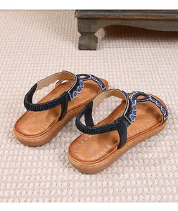 Détail de sandales plates bohèmes avec strass bleus et bride arrière élastique