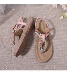 Detail of bohemian T-strap sandal featuring colorful beads and a pink faux gemstone