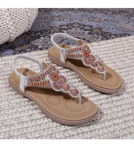 Detail of bohemian T-strap sandals with silver straps and exotic beaded metal accents