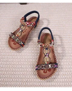 Dettaglio di sandali boho con ricami etnici e soletta stampata a fiori per donne