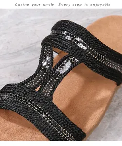 Détail de brides tressées noires avec paillettes argentées sur sandales plates Boho