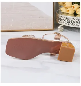Detail of rose gold block heel sandal with rhinestone strap and square toe on marble