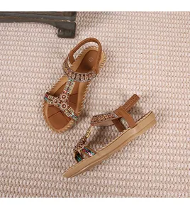 Detail van bohemien sandalen met kleurrijke kralen, metalen bloemen en geweven bandjes
