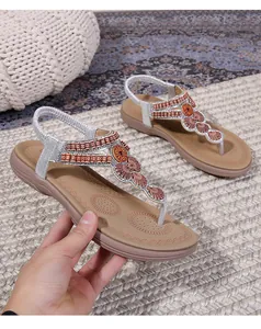 Detail of bohemian flat T-strap sandals with ethnic beads and embroidery