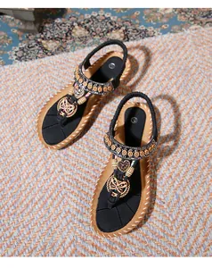 Detail of bohemian flat sandals with floral beadwork, rhinestones, and elastic backstrap