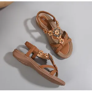 Vue détaillée des sandales plates bohèmes marron avec fleurs en strass et bride élastique
