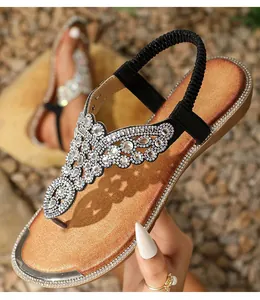 Detail of bohemian flat sandals with sparkling rhinestones and elastic heel strap