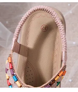 Detail of elastic heel strap and bohemian beadwork on flat rhinestone sandals