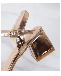 Detailed close-up of metallic rose gold block heel sandal with sleek ankle buckle strap
