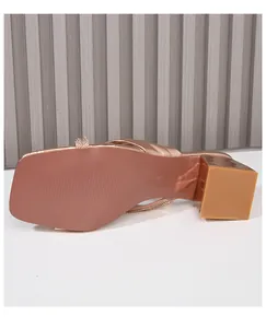 Detalle de sandalia oro rosa con tacón bloque, tiras de strass y suela antideslizante