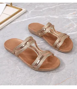 Détail de sandales plates bohèmes avec paillettes et brides tissées métallisées