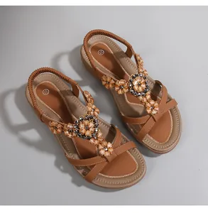 Vue détaillée de sandales bohèmes avec fleurs en perles et lanières en cuir marron