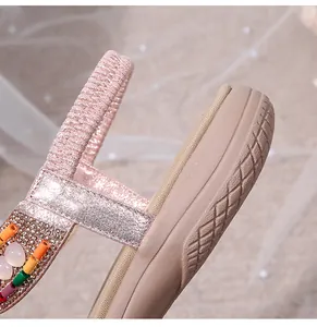 Close-up of pink glitter straps with colorful beads and textured thick anti-slip sole