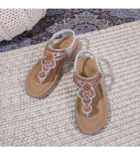 Detail of ethnic thong sandals with intricate geometric beadwork on a woven mat