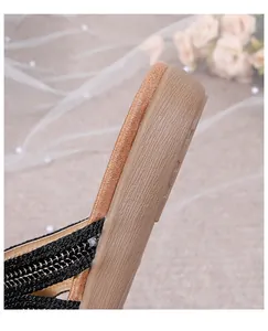 Macro detail of bohemian flat sandals showing wood texture sole and woven straps
