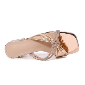 Dames slippers in champagne goud met geknoopte strass bandjes en een vierkante neus