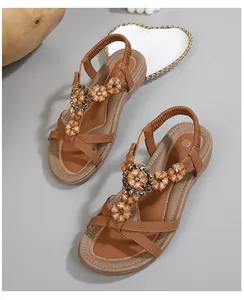 Détail de sandales bohèmes marron avec des fleurs artisanales et des perles décoratives