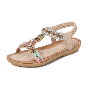 Bohemian platte sandalen met bloemen-strass en T-strap design op witte achtergrond