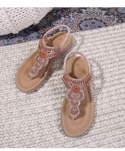 Detail of pink bohemian flip-flop sandals with intricate floral beadwork and rhinestones