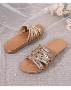 Detail of flat bohemian sandals with golden braided straps and sparkling sequins