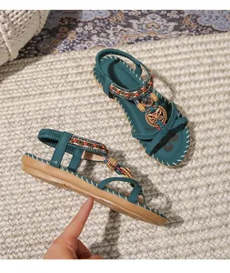 Dettagli di sandali bassi bohémien con perline di legno e ciondoli a cuore verde scuro