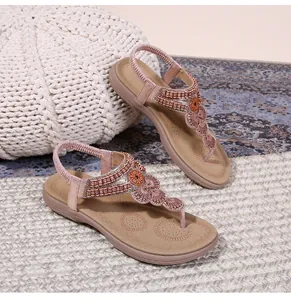 Detail of bohemian flat sandals with sparkling beads, floral sequins and elastic back strap