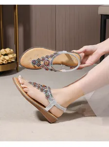 Detail of silver bohemian sandals featuring colorful rhinestone floral T-strap patterns