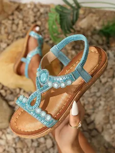 Détail de sandales bohèmes avec perles bleues, pierres turquoise et brides en strass