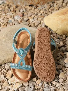 Détails de sandales plates bohèmes avec strass bleus et semelle à motif floral
