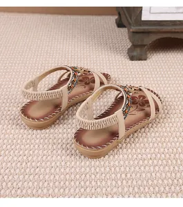 Λεπτομέρεια από μποέμ επίπεδα σανδάλια με στρας και διακοσμητικές χάντρες για γυναίκες