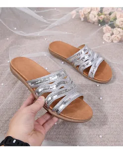 Detail showing silver sequined cross straps and tan footbed of bohemian flat sandals