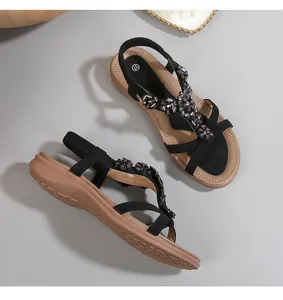 Détail de sandales T-strap bohème avec fleurs perlées sombres et semelle antidérapante