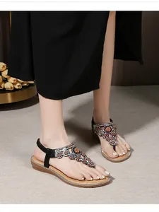 Close-up of bohemian flat sandals featuring colorful rhinestones and floral patterns