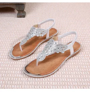 Close-up of silver T-strap sandals with glittering rhinestones and elastic heel strap