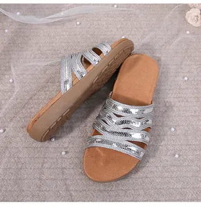 Detail of silver sequined straps and bohemian braided design on flat summer sandals