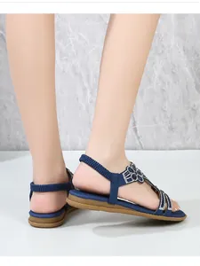 Dettagli di sandali bassi blu da donna con fiori di strass e cinturino elastico sul tallone