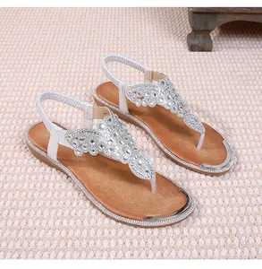 Detailed top view of flat bohemian sandals with crystal embellishments and T-strap design