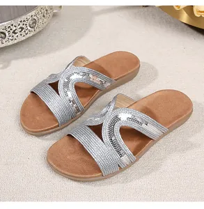 Detailed top view of women's flat silver slide sandals with hollow out geometric pattern