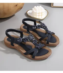 Détail de sandales bohèmes avec perles florales bleues et strass brillants sur la bride en T