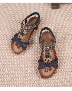 Λεπτομέρεια boho σανδάλια με μπλε λουράκια, έθνικ χάντρες και πεταλούδα μενταγιόν