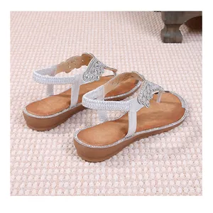 Detail view of women's silver flat sandals with rhinestone bow and elastic back strap