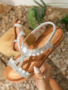 Détail de sandales bohèmes plates avec strass scintillants, perles et bride élastique