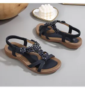 Détail de sandales bohèmes bleu marine avec perles, strass et design de bride en T