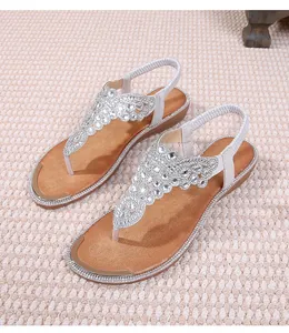 Detailed view of bohemian flat sandals featuring white rhinestones and a flexible back strap