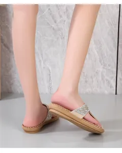 Detalle de sandalias de cuña bohemias con intrincados adornos de celosía de pedrería