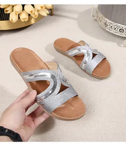 Detail of bohemian silver sequin straps and soft brown cushioned sole on summer flat sandals
