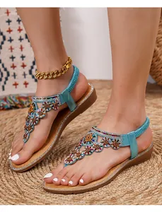 Close-up of bohemian rhinestone flat sandals with crystal sunburst patterns on the T-strap