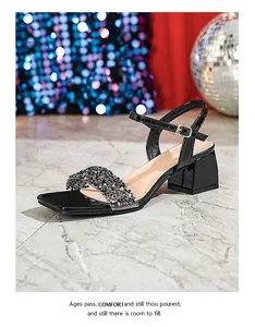 Detail of black patent leather chunky sandals with sparkling rhinestones and square toe